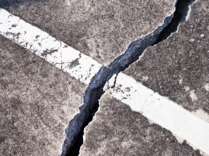 A large crack through a painted line on a road