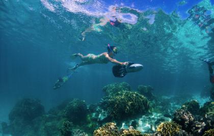 A woman dives with a sea scooter in Rarotonga.
