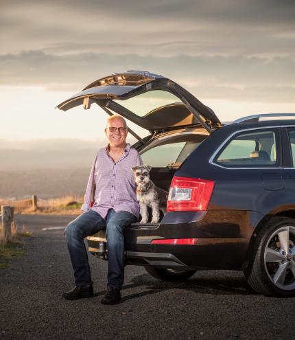 Steve Roome sits in the boot of his modified Skoda Octavia with his dog. 