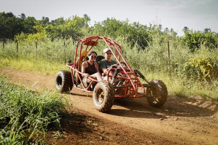 Two people get muddy on a Raro Buggy Tour.