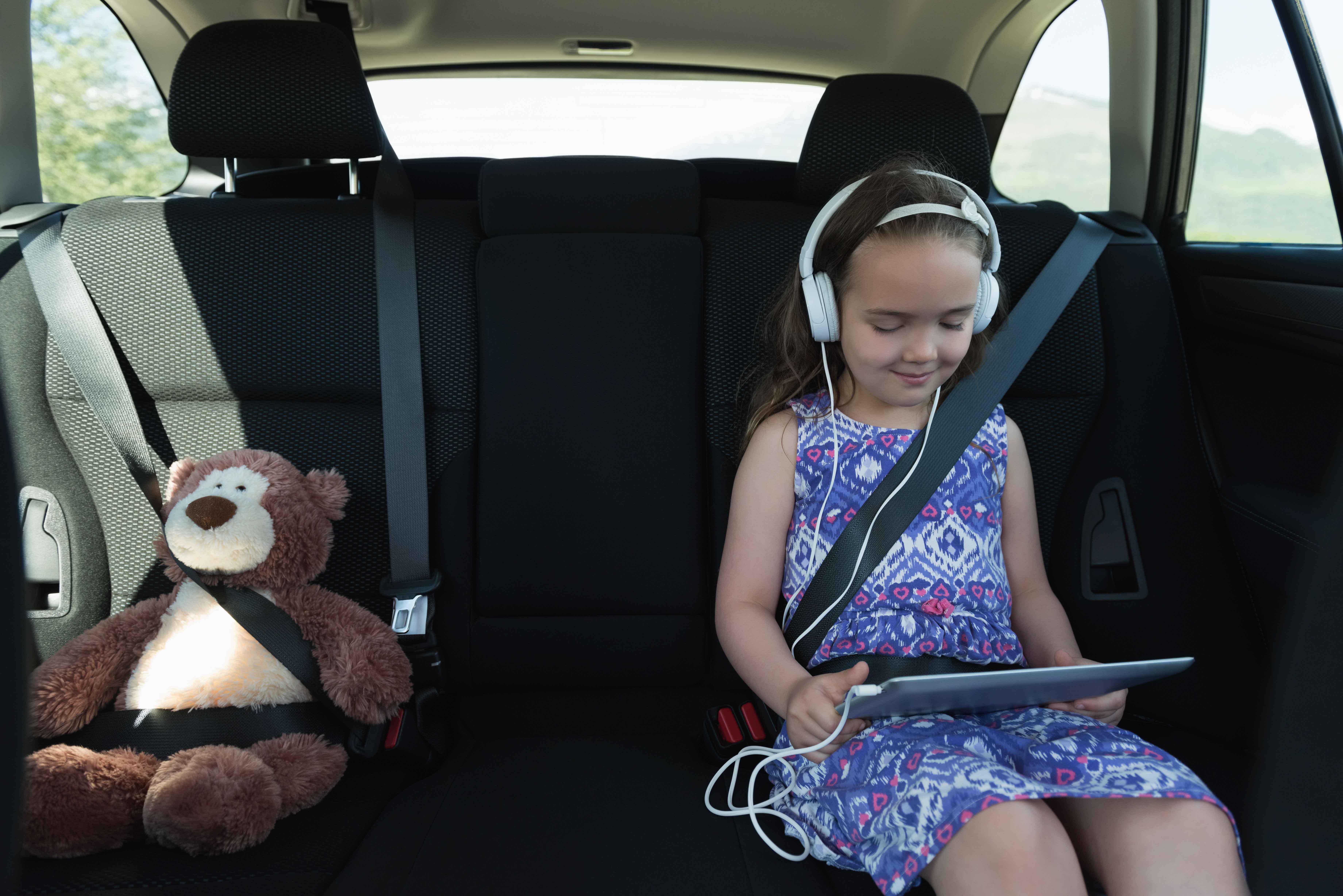 seatbelt listening music on headphone from digital tablet