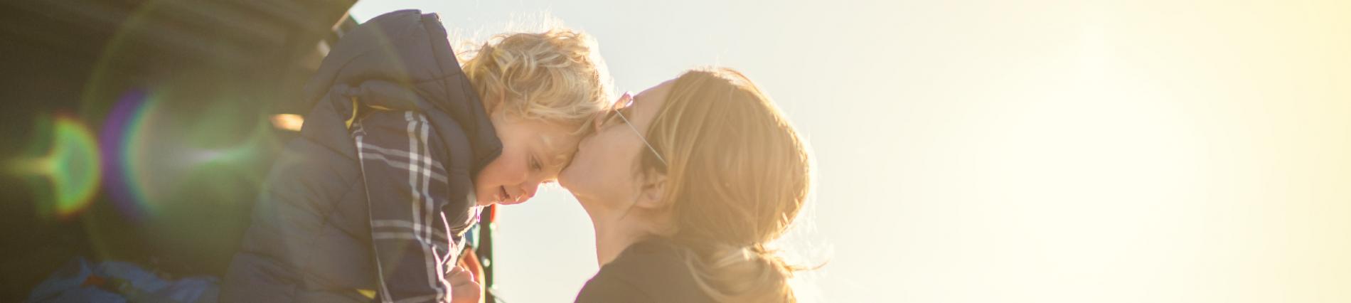 A mother kissing her son on the forehead 